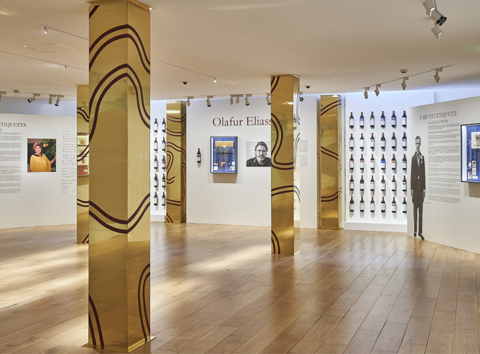 <p>Les colonnes de l’artiste Guy de Rougemont scandent l’espace de L’Exposition l’Art et l’Etiquette.</p>
<p>Le cheminement commence par une partie introductive dédiée à la présentation de la collection et de l’exposition, puis l’artiste ayant réalisé l’œuvre de la dernière étiquette – Olafur Eliasson pour le millésime 2019 – est mis à l’honneur avec une présentation de la « boîte-vitrine ».</p>
<p>Une « bibliothèque » de bouteilles présente tous les millésimes de Château Mouton Rothschild depuis 1924.</p>

